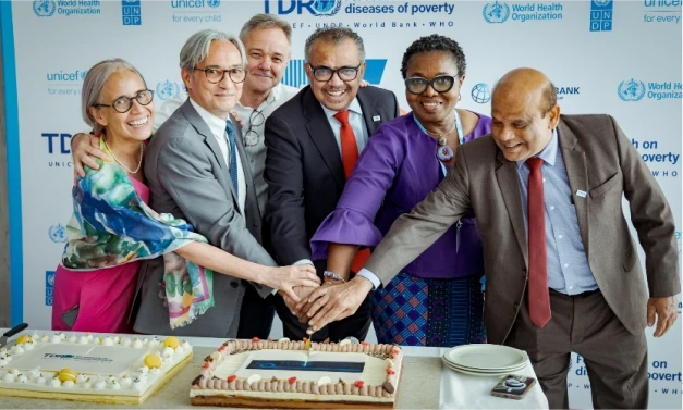 Six health and research leaders, including Dr Tedros Ghebreyesus and Dr John Reeder, cut a cake at a celebratory event for TDR