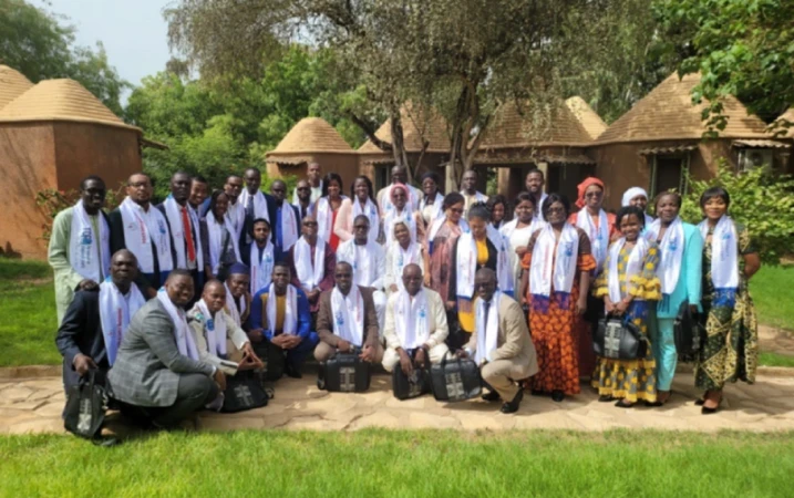 A group of students at Université Cheikh Anta Diop in Senegal posing outdoors, wearing scarves with the TDR logo